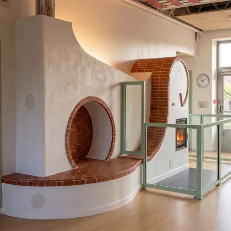 Completed masonry heater finished with terracotta facing tiles and tomette tiles